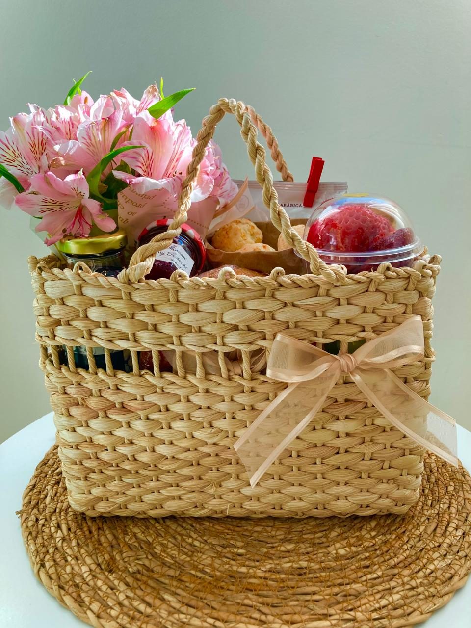 Cesta de café da manhã com flores, pães e doces