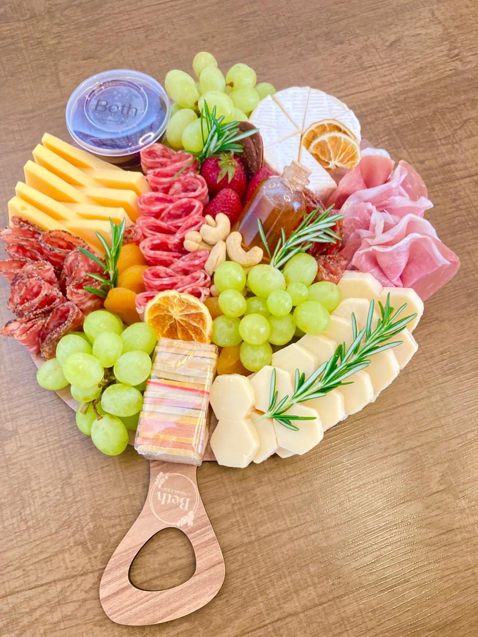 Tábua redonda de queijos, frutas e castanhas